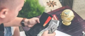 Man holding a wallet full of credit cards and cash.